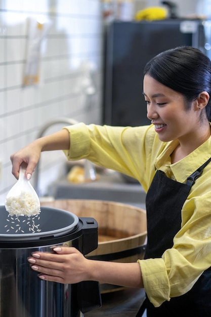 Vrouw die rijst klaarmaakt voor sushi in de keuken van het restaurant