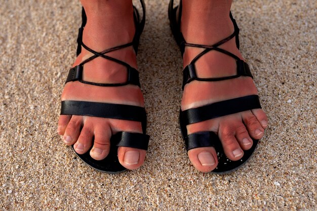 Vrouw die Romeinse sandalen draagt op het strand