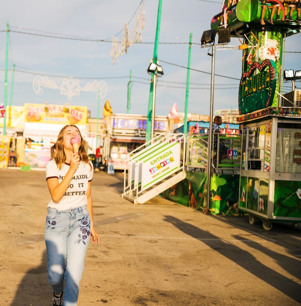 Vrouw die roomijs eet bij pretpark