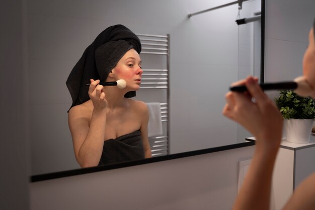 Vrouw die rosacea behandelt die make-up met borstel toepast