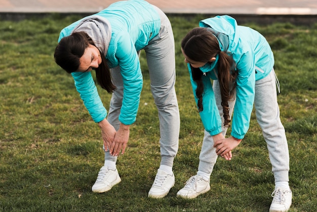 Gratis foto vrouw die samen met dochter op gras opwarmen