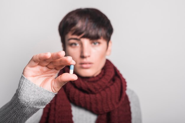 Vrouw die sjaal draagt ​​rond haar hals die capsule toont