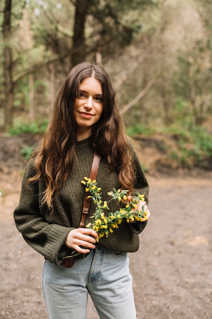 Vrouw die sommige wildflowers in aard houdt