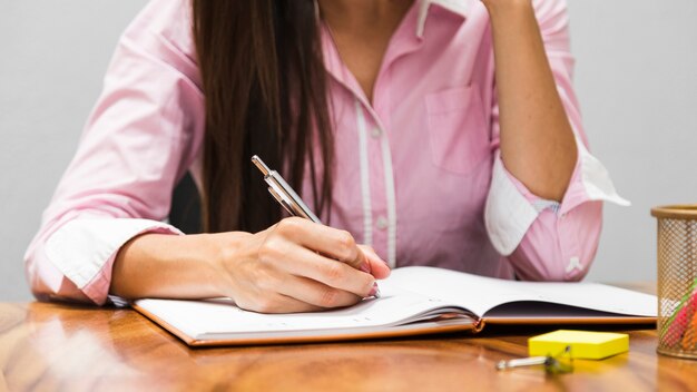 Vrouw die statistieken in agenda schrijft