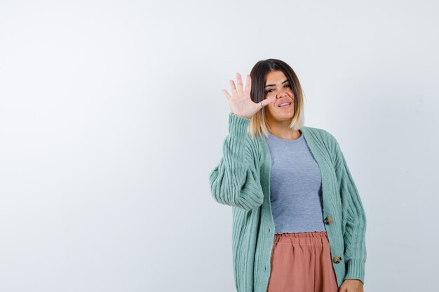 Vrouw die stopgebaar in vrijetijdskleding toont en zelfverzekerd, vooraanzicht kijkt.