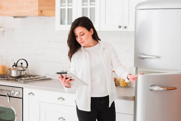 Vrouw die tablet voor ingrediënten bekijkt