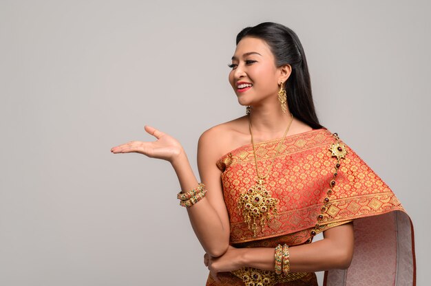 Vrouw die Thaise kleding draagt die een handsymbool maakte