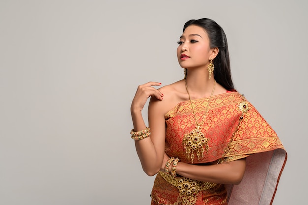 Vrouw die Thaise kleding draagt die een handsymbool maakte