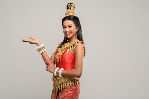 Vrouw die thaise kleding draagt die een handsymbool maakte
