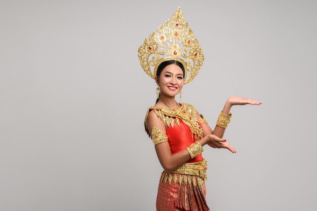 Vrouw die Thaise kleding draagt die een handsymbool maakte