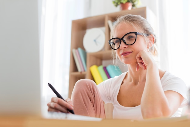 Vrouw die thuis aan bureau werkt