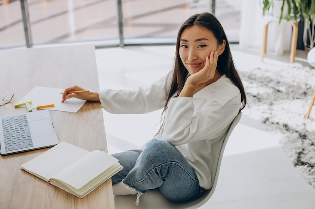 Vrouw die thuis aan de computer aan het bureau werkt