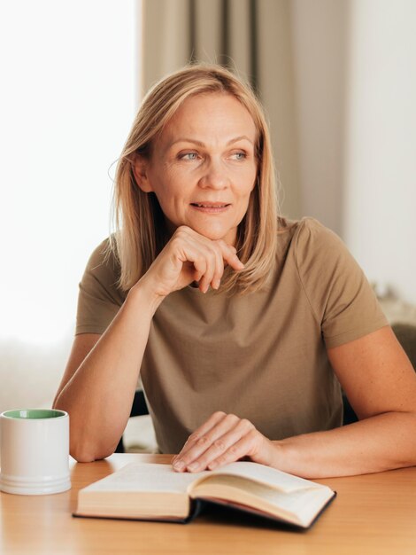 Vrouw die thuis boek leest tijdens zelfisolatie