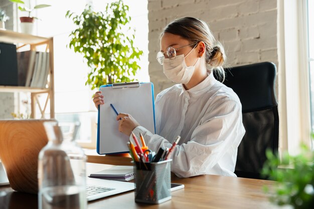 Vrouw die thuis werkt tijdens coronavirus of COVID-19 quarantaine