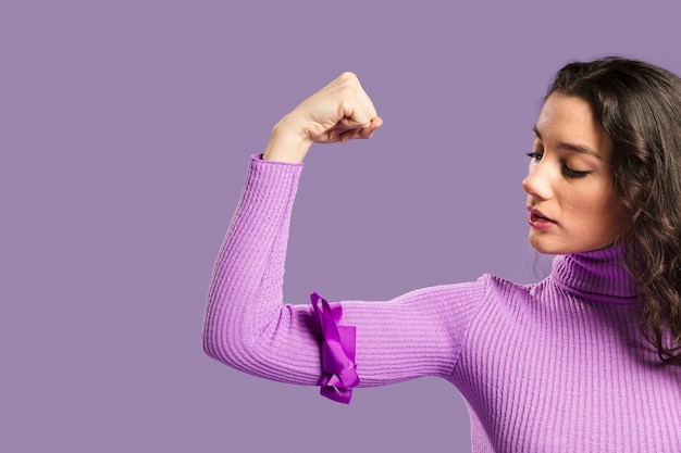 Gratis foto vrouw die trots haar wapenspieren bekijkt