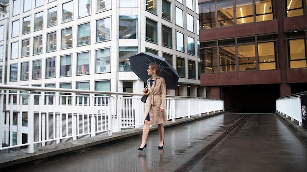 Gratis foto vrouw die uitgaat in de stad terwijl het regent