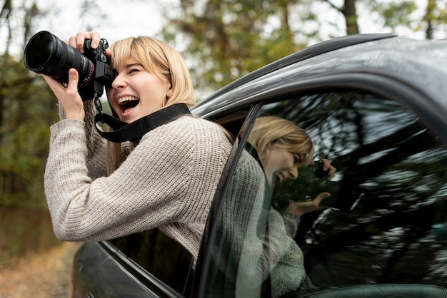 Gratis foto vrouw die van bewegende auto fotografeert