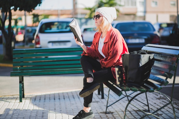 Vrouw die van boek op straat geniet