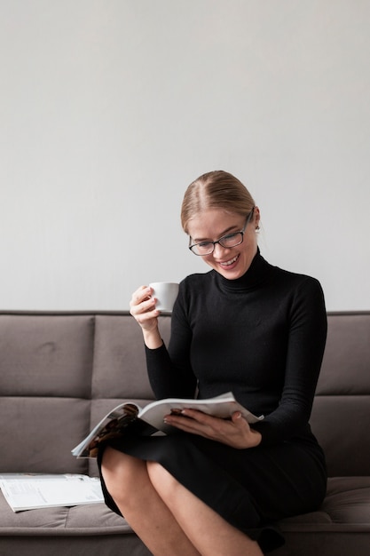 Vrouw die van koffie geniet en tijdschrift leest