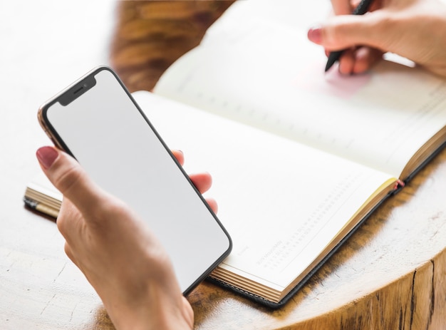 Vrouw die van telefoonmodel schrijft