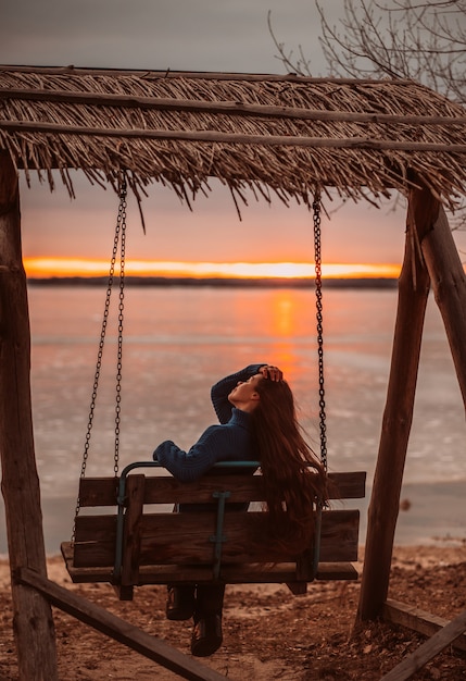 Vrouw die van tijd het ontspannen geniet door het mooie meer bij zonsopgang