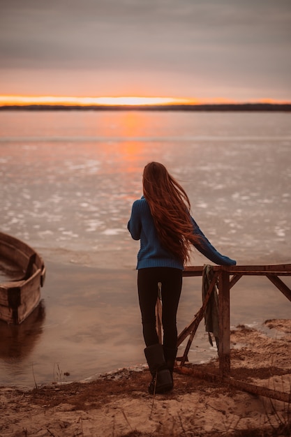Vrouw die van tijd het ontspannen geniet door het mooie meer bij zonsopgang