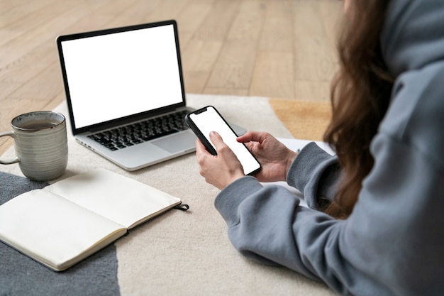 Gratis foto vrouw die vanuit huis op de vloer werkt met apparaat