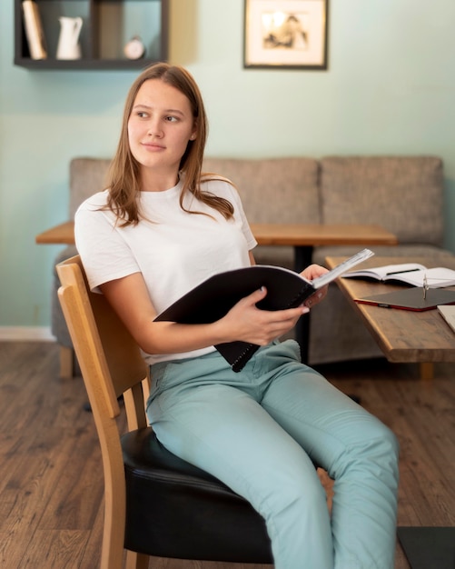 Vrouw die vanuit huis werkt tijdens de pandemie met notitieboekje