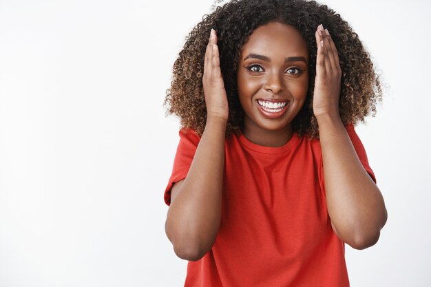 Vrouw die verbazingwekkend en verbazingwekkend positief nieuws leert en er verrast en geamuseerd uitziet en handpalmen opheft in de buurt van het gezicht glimlachend breed van opwinding en geluk knallende ogen onder de indruk aan de voorkant