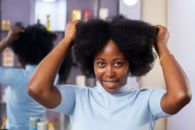 Vrouw die voor haar afro-haar zorgt