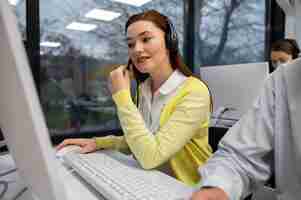 Gratis foto vrouw die wordt gebeld tijdens het werk in een callcenter