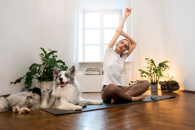 Vrouw die yoga doet vergezeld van hun huisdier