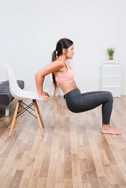 Vrouw die yoga thuis doet