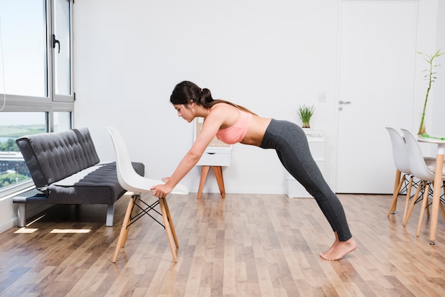 Vrouw die yoga thuis doet