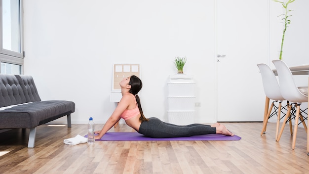 Vrouw die yoga thuis doet