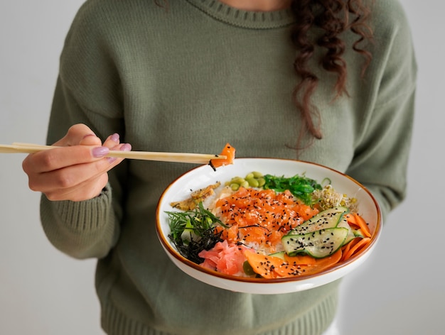 Vrouw die zeevruchtenschotel met zalm eet