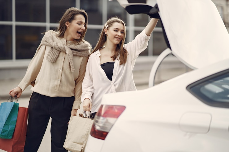 Gratis Foto vrouw die zich door de auto met het winkelen zakken bevindt