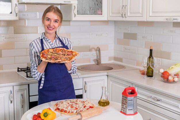 Vrouw die zich met pizza in handen bevindt