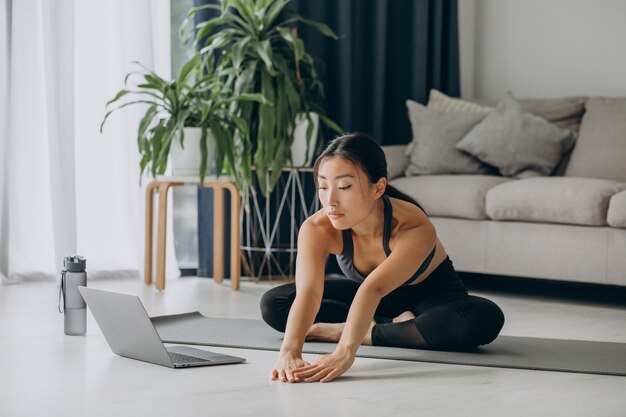 Vrouw die zich thuis uitstrekt op yogamat