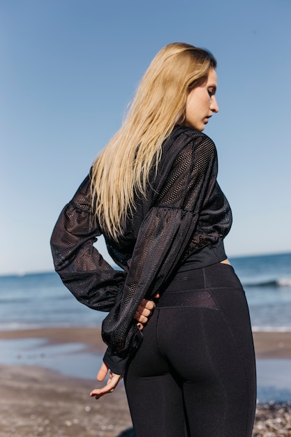 Vrouw die zich uitstrekt op het strand