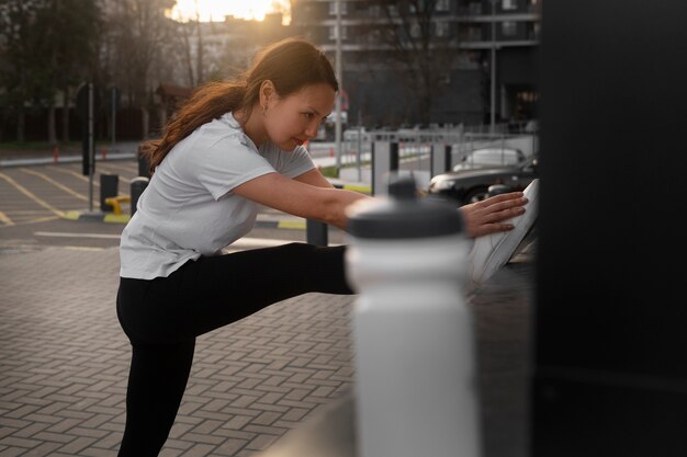 Vrouw die zich uitstrekt voordat ze buitenshuis gaat trainen