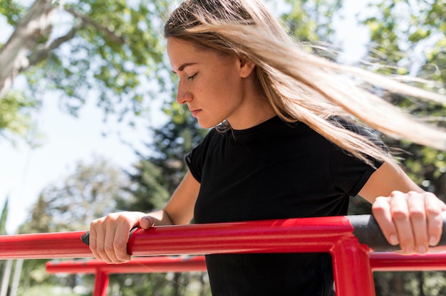 Vrouw die zich vasthoudt op een metalen staaf