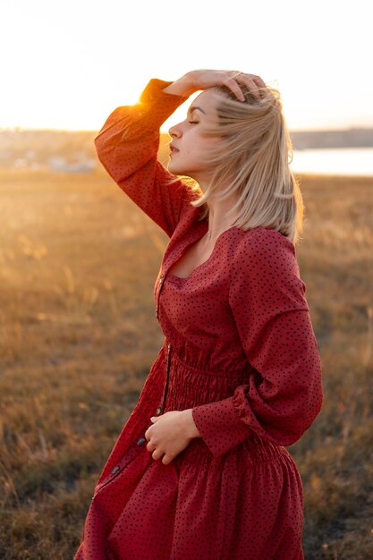 Vrouw die zich voordeed bij zonsondergang zijaanzicht