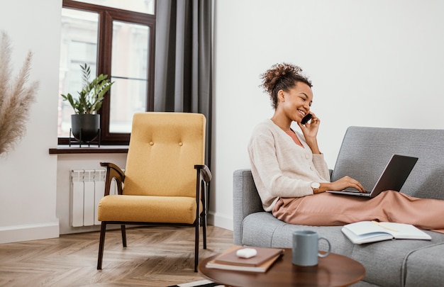 Vrouw die zittend op de bank werkt