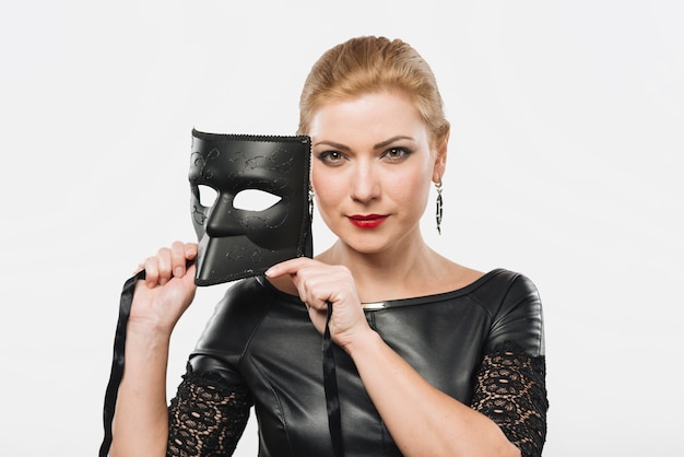 Gratis foto vrouw die zwart masker in handen houdt