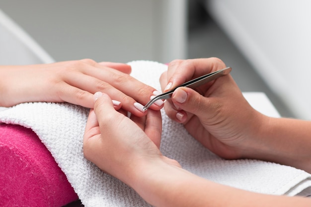 Vrouw doet de manicure van een close-up van de cliënt