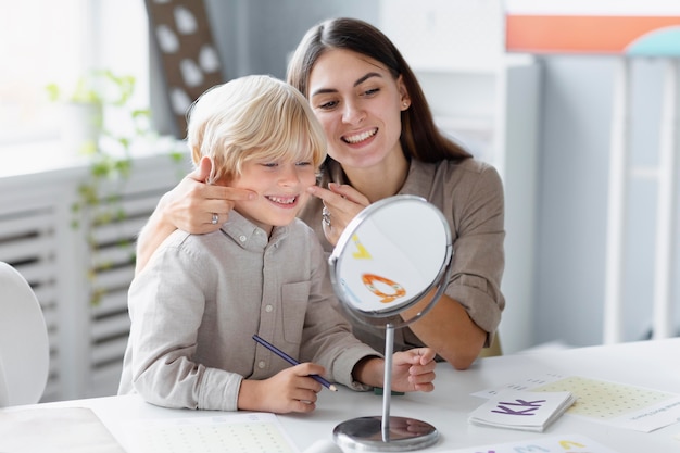 Vrouw doet logopedie met een kleine jongen in haar kliniek