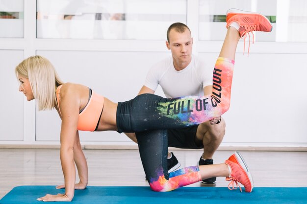 Vrouw doet oefeningen met trainer