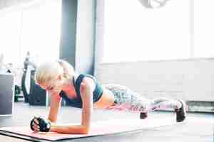 Gratis foto vrouw doet plank oefening in de sportschool