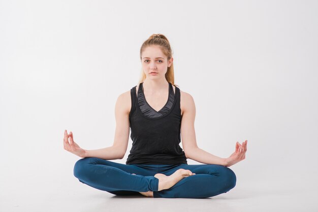 Vrouw doet thuis meditatie op de vloer